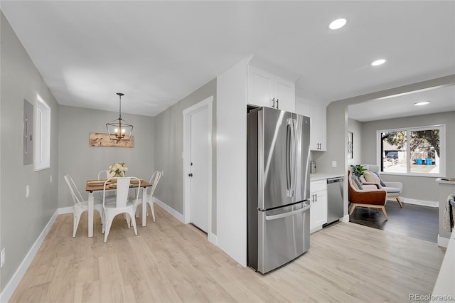 kitchen featuring appliances with stainless steel finishes, light countertops, white cabinetry, and light wood finished floors