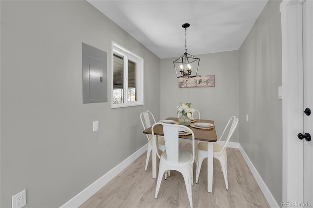 dining space with electric panel, light wood-style flooring, and baseboards