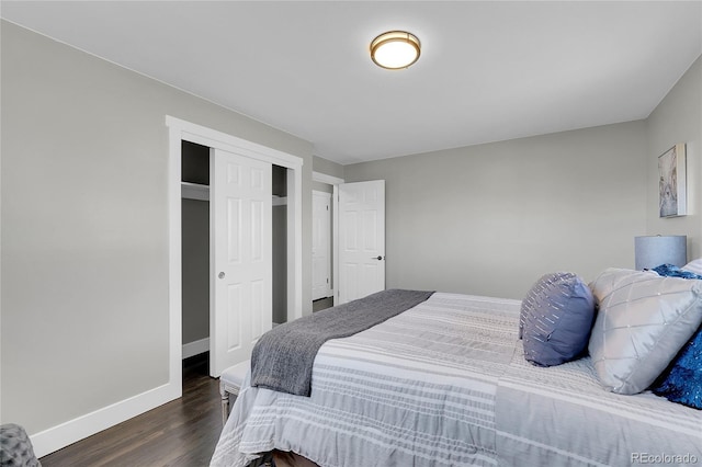 bedroom with dark wood-style floors, a closet, and baseboards