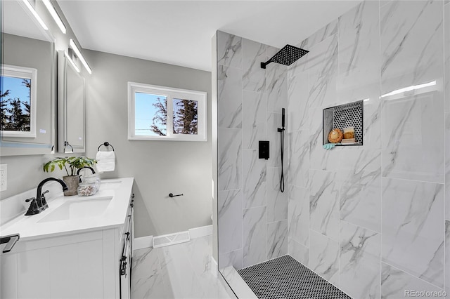 bathroom with a sink, baseboards, marble finish floor, a marble finish shower, and double vanity