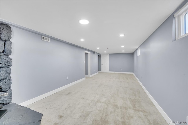 below grade area featuring light carpet, baseboards, visible vents, and recessed lighting