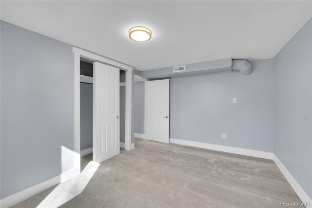 unfurnished bedroom featuring carpet, a closet, visible vents, and baseboards