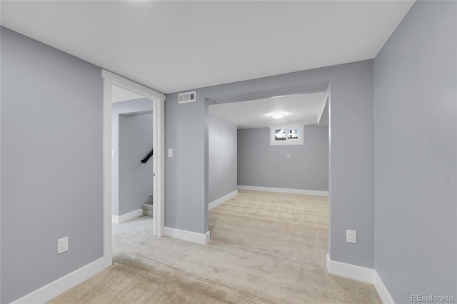 basement featuring carpet floors, visible vents, stairway, and baseboards