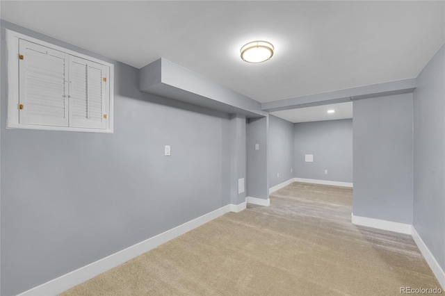 finished basement featuring light carpet and baseboards