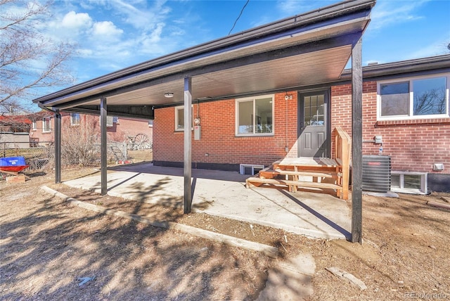 back of property featuring brick siding, fence, and central air condition unit