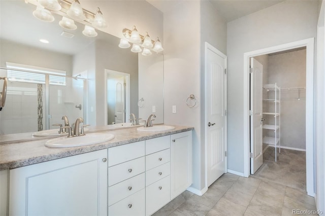 6093 Rowdy Dr, Colorado Springs, CO 80924 - bathroom featuring a walk in closet, double vanity, a shower stall, and a sink