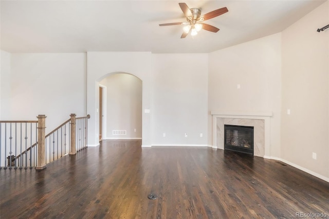 6093 Rowdy Dr, Colorado Springs, CO 80924 - unfurnished living room featuring ceiling fan, arched walkways, wood finished floors, and a high end fireplace