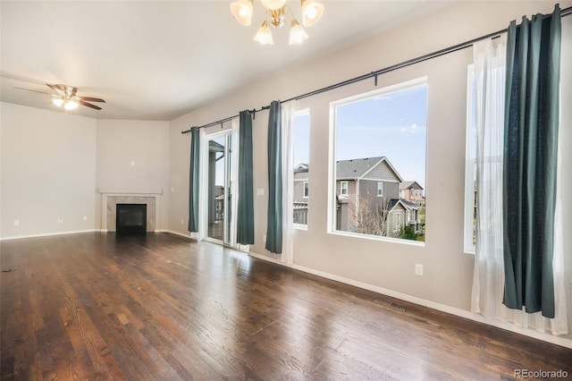 6093 Rowdy Dr, Colorado Springs, CO 80924 - unfurnished living room featuring a high end fireplace, baseboards, wood finished floors, and ceiling fan with notable chandelier