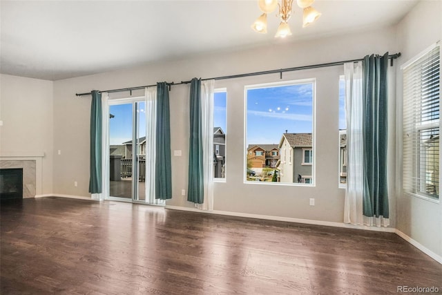 6093 Rowdy Dr, Colorado Springs, CO 80924 - unfurnished living room featuring a chandelier, a premium fireplace, wood finished floors, and baseboards