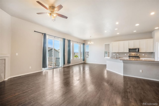 6093 Rowdy Dr, Colorado Springs, CO 80924 - unfurnished living room with dark wood finished floors, recessed lighting, baseboards, and ceiling fan with notable chandelier