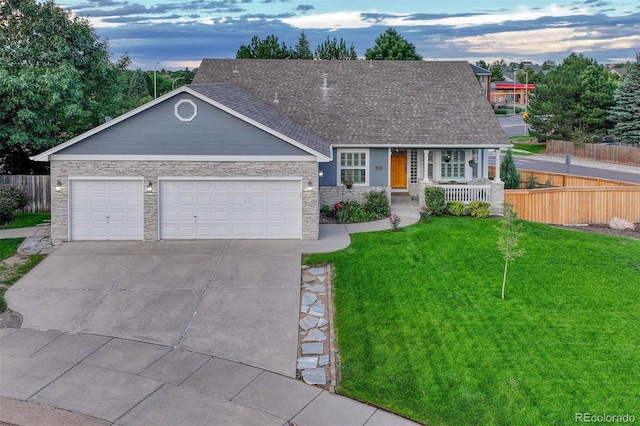 view of front of home with covered porch, a yard, and a garage