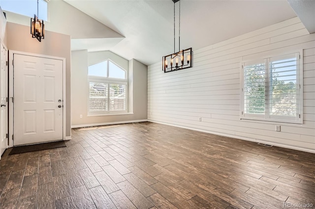 9385 Pepperwood Ln, Highlands Ranch, CO 80126 - unfurnished dining area featuring lofted ceiling, a chandelier, dark wood-style flooring, and wooden walls