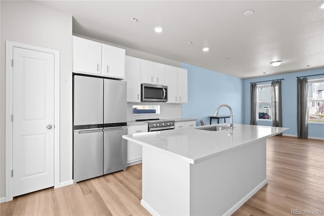 9257 Mayflower Gulch Way, Colorado Springs, CO 80927 - kitchen featuring stainless steel appliances, a sink, light wood-style floors, white cabinetry, and recessed lighting