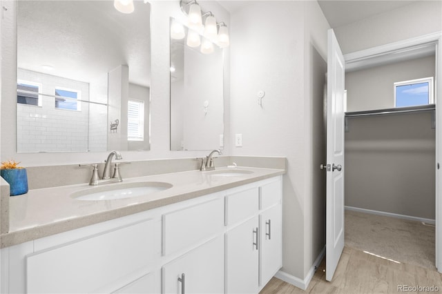 9257 Mayflower Gulch Way, Colorado Springs, CO 80927 - full bathroom with double vanity, a walk in closet, and baseboards