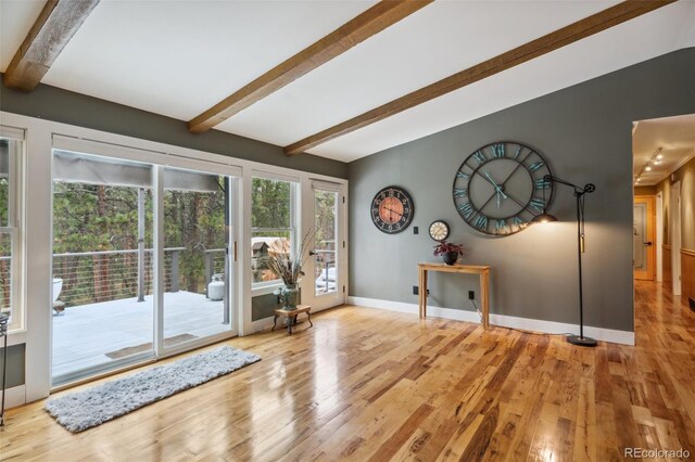 interior space with wood finished floors, baseboards, and beam ceiling