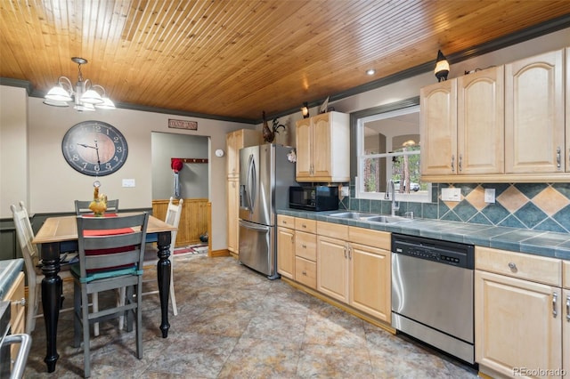 kitchen featuring tile counters, light brown cabinetry, appliances with stainless steel finishes, and a sink
