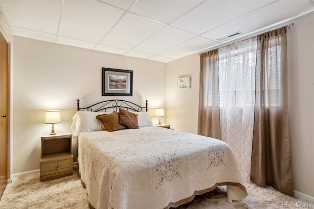 bedroom featuring carpet, baseboards, visible vents, and a drop ceiling