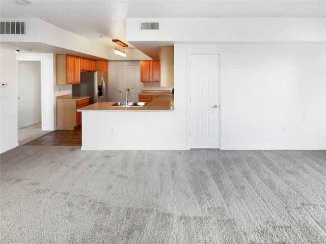 kitchen with sink, light carpet, kitchen peninsula, and stainless steel fridge with ice dispenser