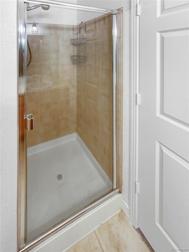 bathroom featuring tile patterned flooring and a shower with shower door