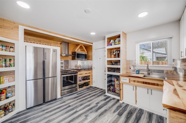935 Newark St, Aurora, CO 80010 - kitchen with appliances with stainless steel finishes, wall chimney range hood, tasteful backsplash, light wood finished floors, and open shelves