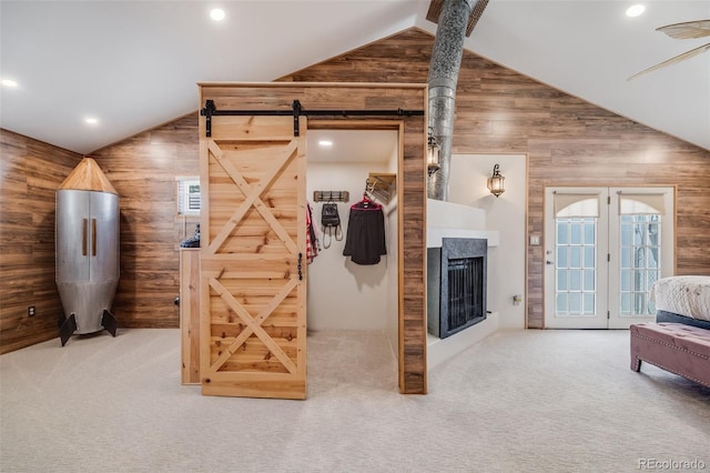 935 Newark St, Aurora, CO 80010 - carpeted bedroom featuring lofted ceiling, wood walls, recessed lighting, access to exterior, and a multi sided fireplace