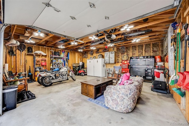 935 Newark St, Aurora, CO 80010 - garage with freestanding refrigerator, a garage door opener, and a workshop area