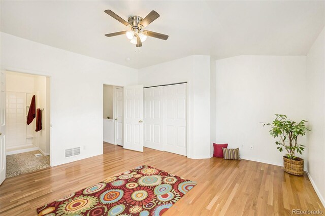 bedroom featuring hardwood / wood-style flooring, ceiling fan, and connected bathroom