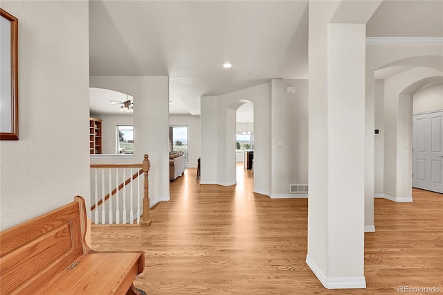 19045 Shiloh Ranch Dr, Colorado Springs, CO 80908 - hallway with arched walkways, light wood finished floors, baseboards, an upstairs landing, and recessed lighting