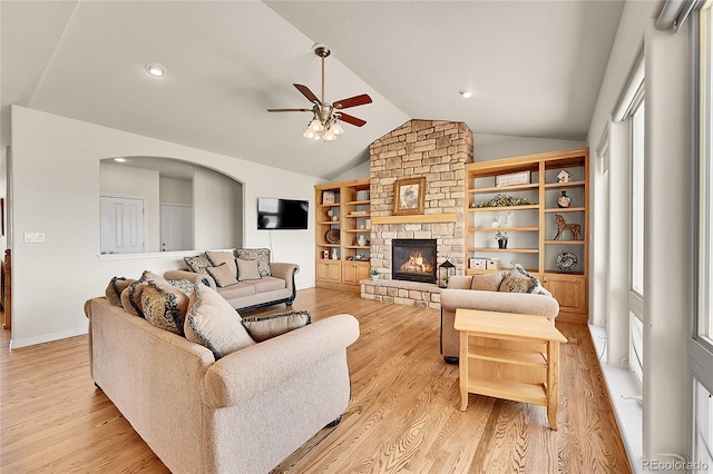 19045 Shiloh Ranch Dr, Colorado Springs, CO 80908 - living area with a ceiling fan, vaulted ceiling, light wood finished floors, a fireplace, and arched walkways