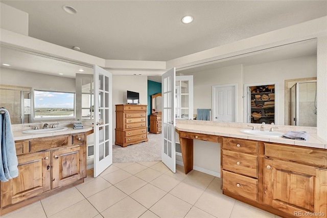 19045 Shiloh Ranch Dr, Colorado Springs, CO 80908 - bathroom with french doors, a stall shower, two vanities, tile patterned floors, and a walk in closet