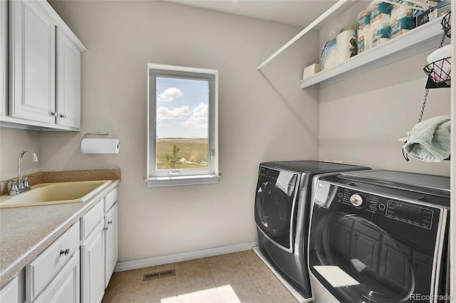 19045 Shiloh Ranch Dr, Colorado Springs, CO 80908 - clothes washing area with washing machine and dryer, cabinet space, baseboards, and light tile patterned floors