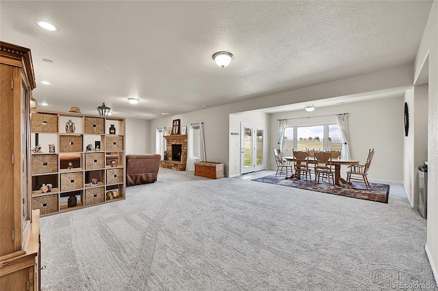 19045 Shiloh Ranch Dr, Colorado Springs, CO 80908 - living area featuring carpet floors, a fireplace with raised hearth, baseboards, recessed lighting, and a textured ceiling