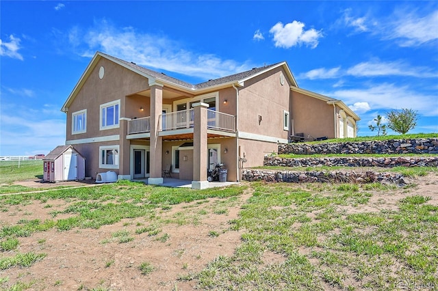 19045 Shiloh Ranch Dr, Colorado Springs, CO 80908 - rear view of house featuring stucco siding, a balcony, a storage shed, a patio area, and an outbuilding