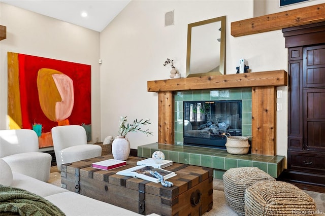 living area with high vaulted ceiling, visible vents, and a tiled fireplace