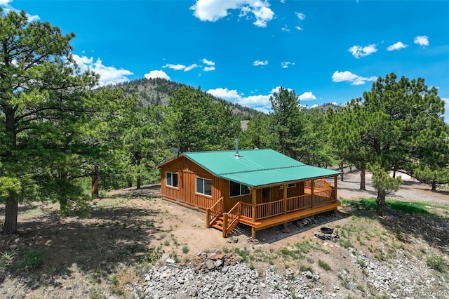 70 Elk Cir, Guffey, CO 80820 - back of property featuring a forest view, board and batten siding, a metal roof, and a deck with mountain view