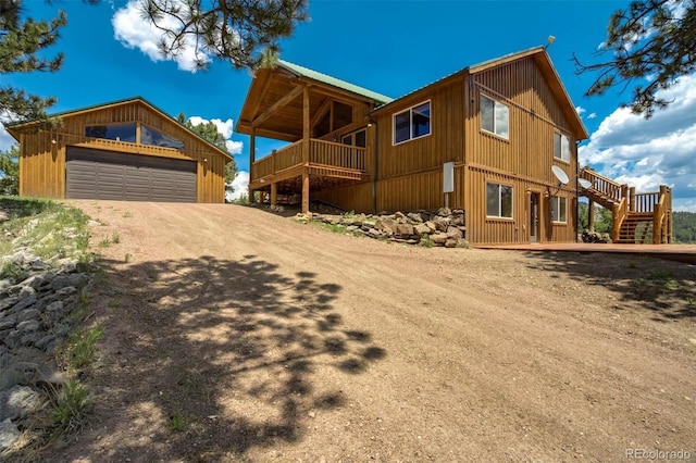 70 Elk Cir, Guffey, CO 80820 - view of front of house featuring a garage, an outbuilding, stairs, and a wooden deck