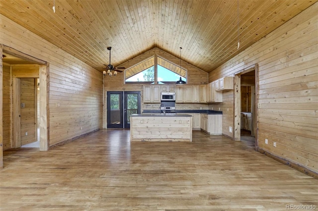 70 Elk Cir, Guffey, CO 80820 - kitchen with white microwave, dark countertops, wooden walls, light wood-style flooring, and high vaulted ceiling