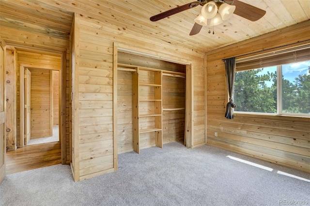 70 Elk Cir, Guffey, CO 80820 - unfurnished bedroom with wood walls, carpet flooring, wood ceiling, a ceiling fan, and a closet