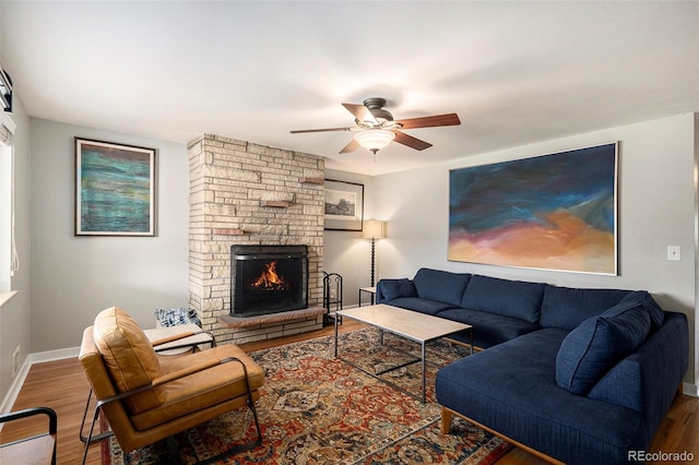 living room with baseboards, a fireplace, a ceiling fan, and wood finished floors