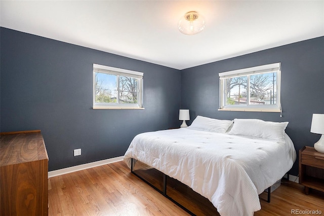 bedroom with baseboards and wood finished floors