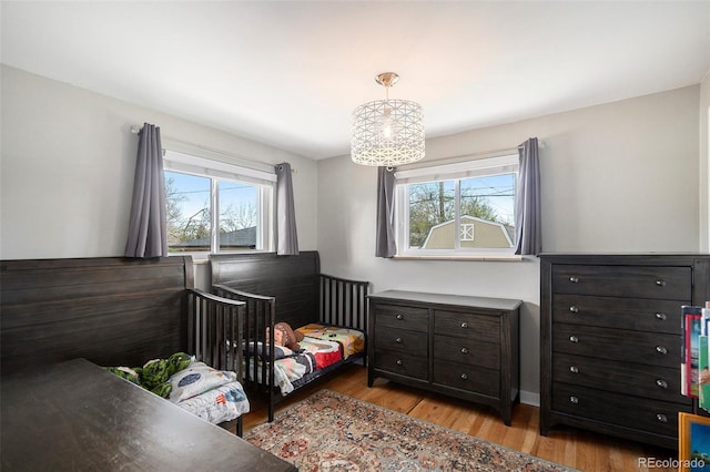 bedroom with multiple windows and light wood-type flooring