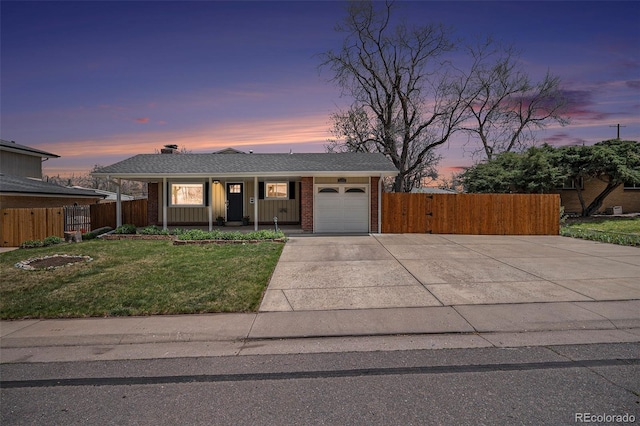 view of front facade with a garage, a front lawn, fence, and concrete driveway