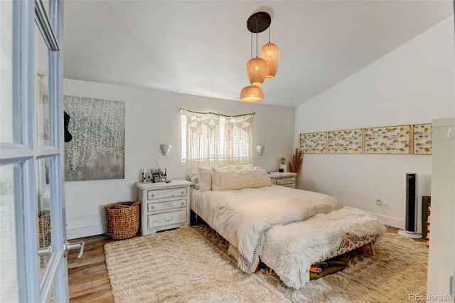 bedroom with wood finished floors and lofted ceiling