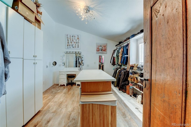 spacious closet with lofted ceiling and light wood-style flooring