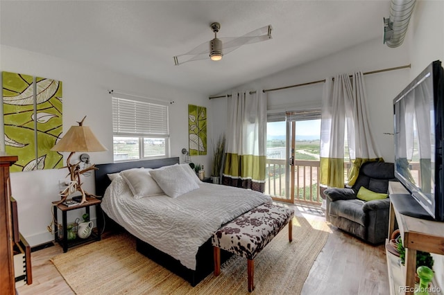 bedroom featuring light wood-style floors, access to outside, lofted ceiling, and ceiling fan