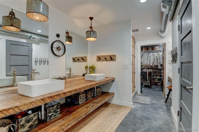 full bath featuring baseboards, concrete floors, double vanity, recessed lighting, and a spacious closet