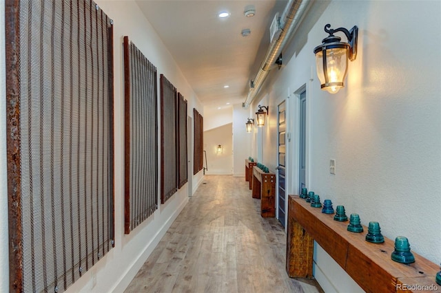 hall with light wood-style floors and recessed lighting