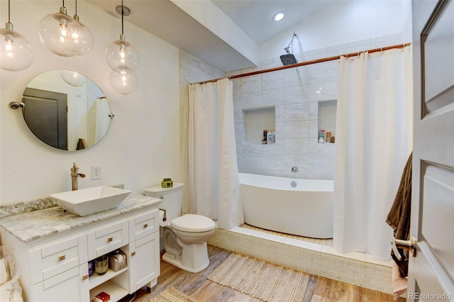 bathroom featuring wood finished floors, lofted ceiling, toilet, a shower with curtain, and vanity