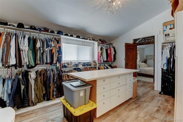 walk in closet with lofted ceiling and light wood-style floors