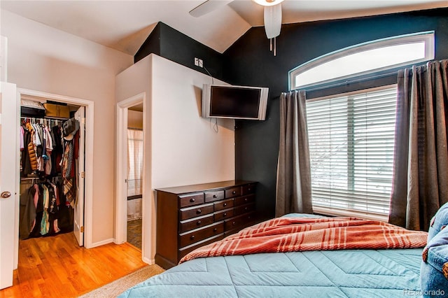 bedroom featuring ceiling fan, a spacious closet, multiple windows, a closet, and lofted ceiling